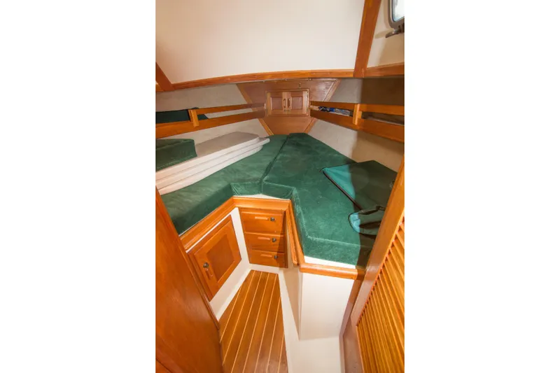 Slide: The Image of Cozy cabin interior of 1992 Pacific Seacraft 34 sailboat with green cushions and wooden cabinetry. - 18