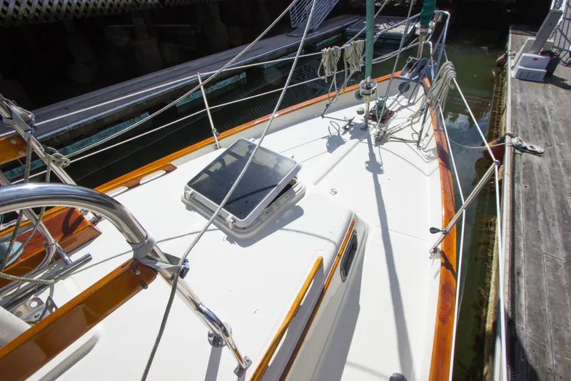 Slide: The Image of 1992 Pacific Seacraft 34 sailboat deck with wooden trim and hatch, docked in marina. - 24
