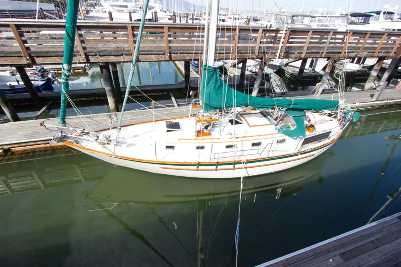 Slide: The Image of 1992 Pacific Seacraft 34 sailboat docked at a marina with green covers. - 5