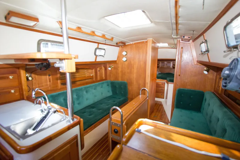 Slide: The Image of Interior of a 1992 Pacific Seacraft 34 sailboat with wood finish and green upholstery. - 7