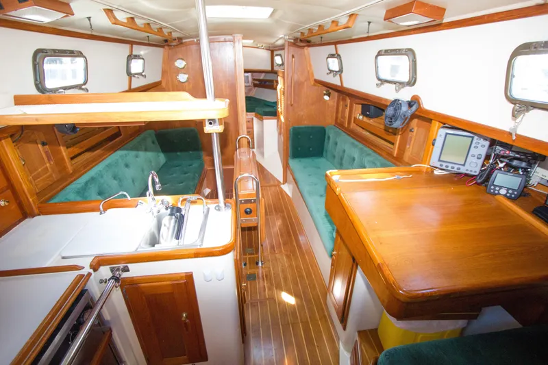 Slide: The Image of Interior of 1992 Pacific Seacraft 34 sailboat with wood finish and green upholstery. - 8