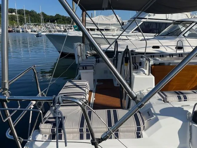 Slide: The Image of 2017 Beneteau Oceanis 38.1 sailboat docked at marina, featuring spacious deck and seating. - 16