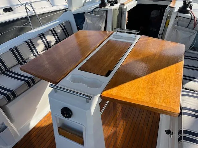 Slide: The Image of Cockpit of 2017 Beneteau Oceanis 38.1 with wooden table and striped seating. - 19