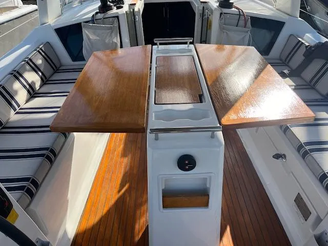 Slide: The Image of 2017 Beneteau Oceanis 38.1 cockpit with wooden table and striped seating. - 20
