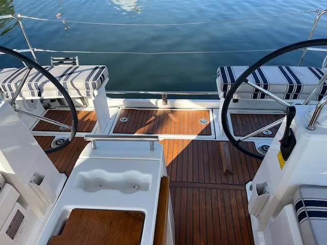 Slide: The Image of Cockpit of 2017 Beneteau Oceanis 38.1 sailboat with dual steering wheels and striped seating. - 23
