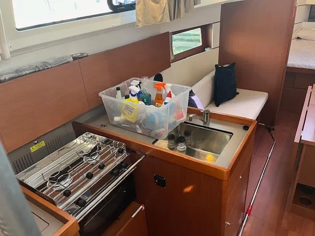 Slide: The Image of Interior of 2017 Beneteau Oceanis 38.1 yacht with kitchen and seating area. - 26