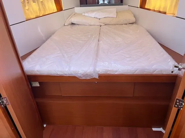 Slide: The Image of Cabin bed in 2017 Beneteau Oceanis 38.1 yacht, featuring wooden finish and cozy bedding. - 32