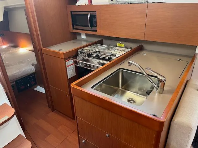 Slide: The Image of 2017 Beneteau Oceanis 38.1 yacht kitchen with sink, stove, and microwave. - 33