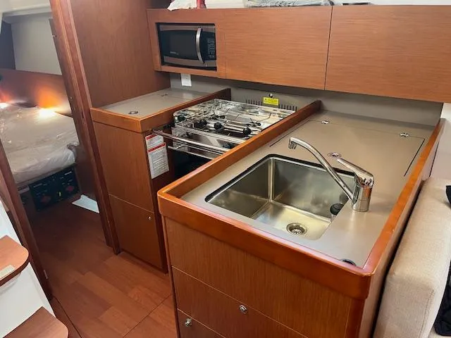Slide: The Image of 2017 Beneteau Oceanis 38.1 yacht kitchen with sink, stove, and microwave. - 34