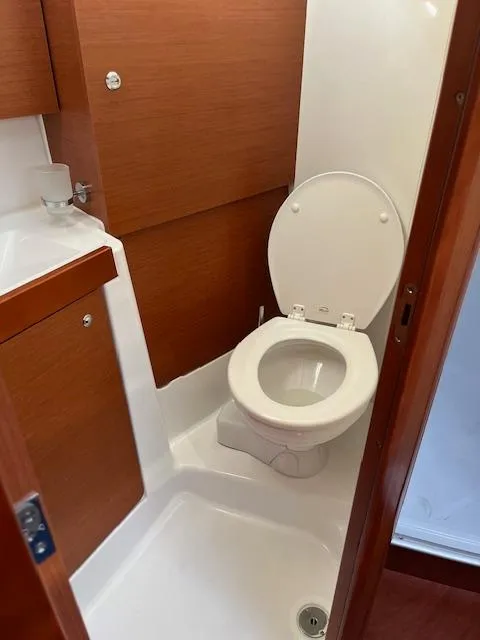 Slide: The Image of 2017 Beneteau Oceanis 38.1 yacht bathroom with wooden cabinetry and white toilet. - 35