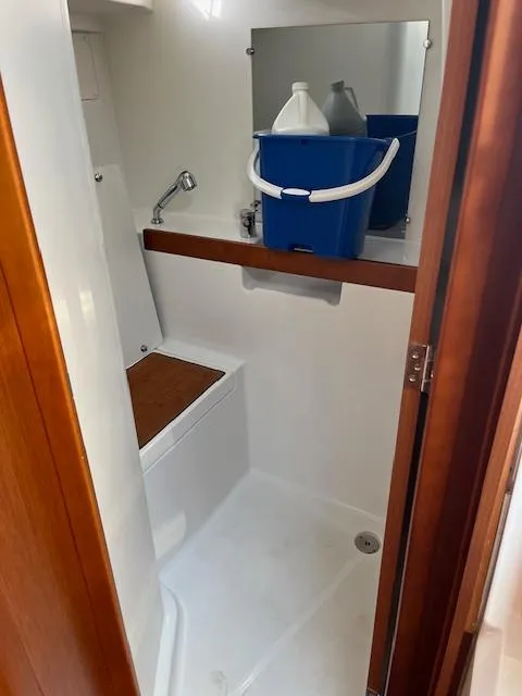 Slide: The Image of Beneteau Oceanis 38.1 2017 bathroom with shower, wooden accents, and storage shelf. - 36