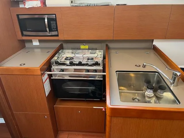 Slide: The Image of Galley kitchen in 2017 Beneteau Oceanis 38.1 yacht with stove, sink, and microwave. - 44