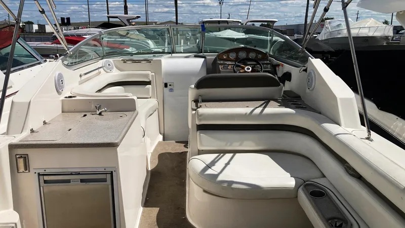 Slide: The Image of 2007 Rinker 280 Express Cruiser interior with seating and helm, docked at marina. - 10