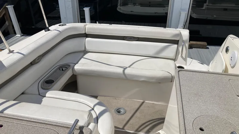 Slide: The Image of 2007 Rinker 280 Express Cruiser interior with white seating and cup holders. - 11