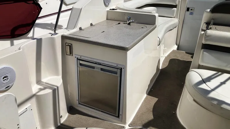 Slide: The Image of 2007 Rinker 280 Express Cruiser interior with kitchenette and seating area. - 12