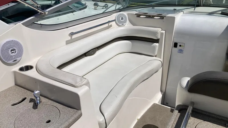 Slide: The Image of 2007 Rinker 280 Express Cruiser interior seating with beige upholstery and built-in speakers. - 14