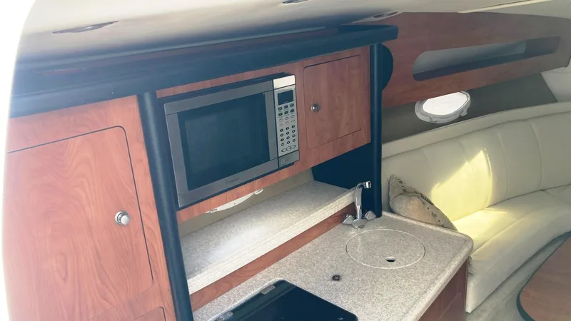 Slide: The Image of 2007 Rinker 280 Express Cruiser interior with kitchenette and seating area. - 17