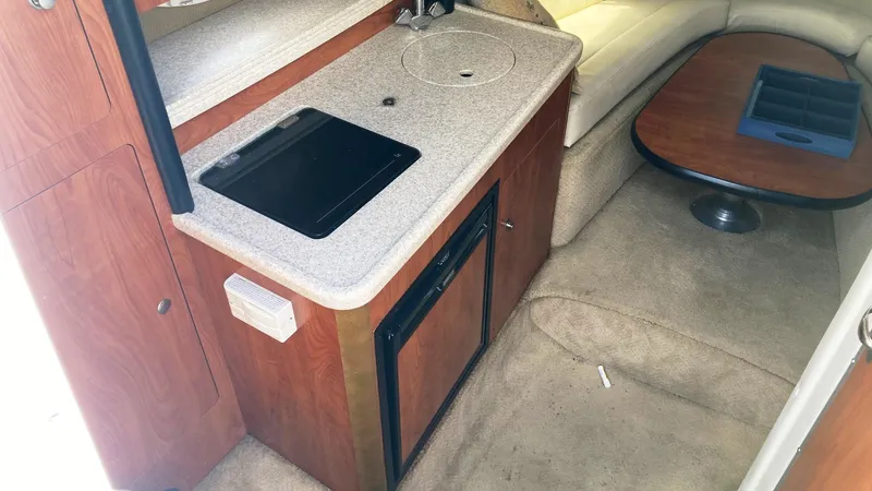 Slide: The Image of 2007 Rinker 280 Express Cruiser interior with kitchenette and seating area. - 18