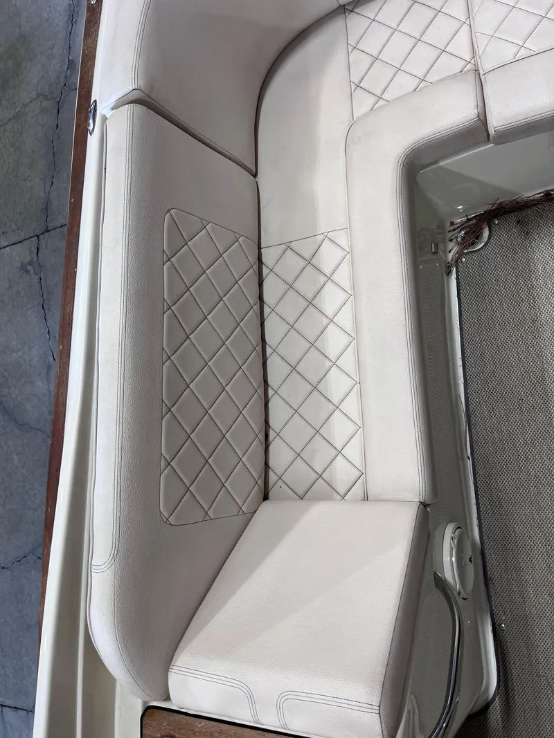 Slide: The Image of 2018 Chris-Craft 27 Launch boat interior with diamond-stitched white leather seating. - 5
