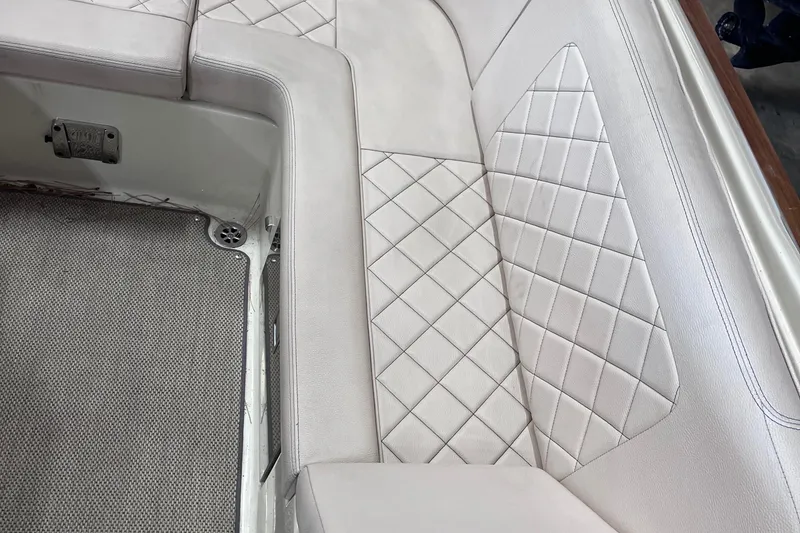 Slide: The Image of 2018 Chris-Craft 27 Launch boat interior with diamond-stitched white leather seating. - 6