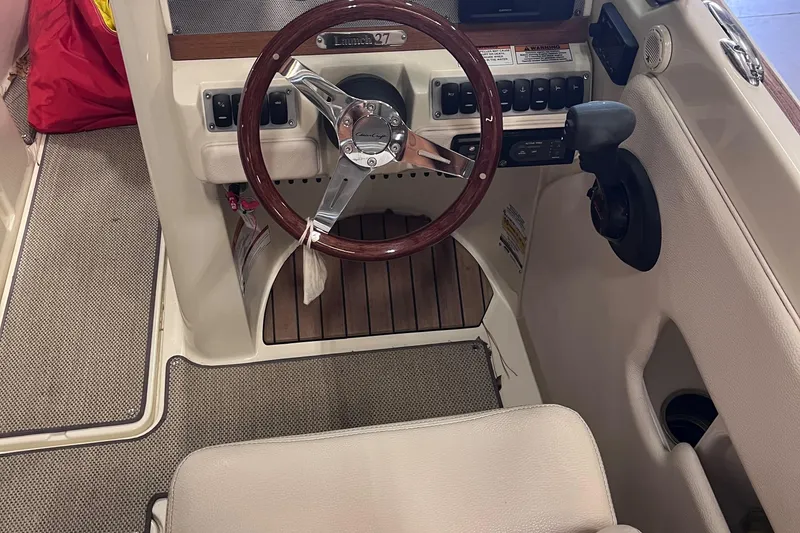 Slide: The Image of 2018 Chris-Craft 27 Launch boat interior with steering wheel and control panel. - 8