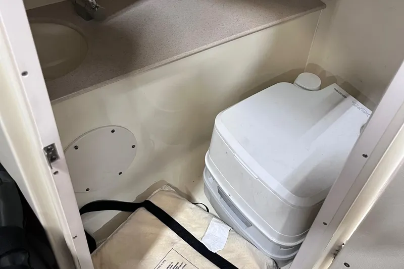 Slide: The Image of 2018 Chris-Craft 27 Launch interior with portable toilet and storage area. - 9