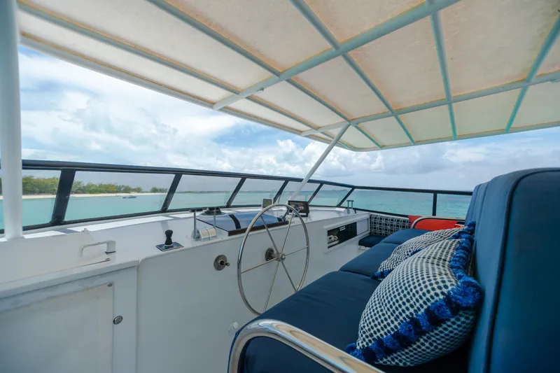 Slide: The Image of 1991 Broward Motor Yacht helm with ocean view and cushioned seating. - 10