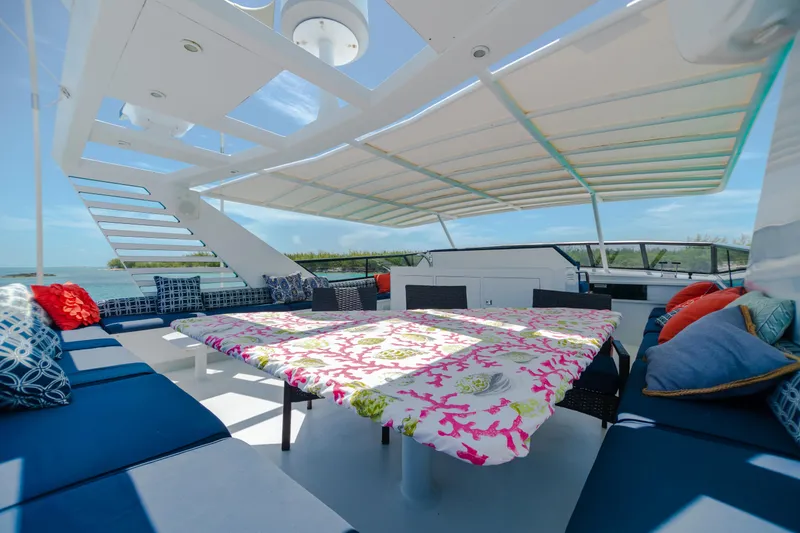 Slide: The Image of Spacious deck of 1991 Broward Motor Yacht with colorful seating and table. - 15