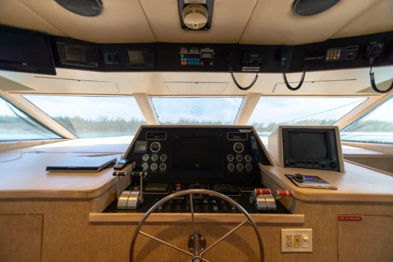 Slide: The Image of 1991 Broward Motor Yacht helm with navigation equipment and steering wheel. - 26