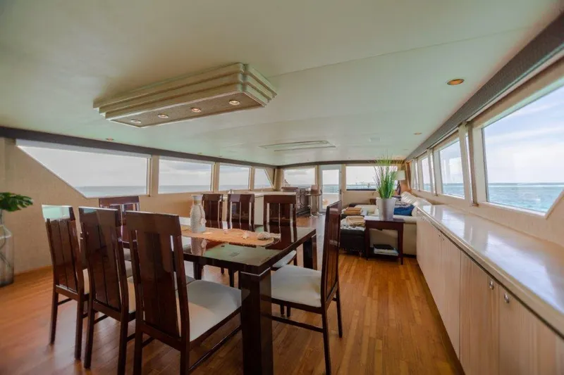 Slide: The Image of Luxurious dining area inside a 1991 Broward Motor Yacht with panoramic ocean views. - 27