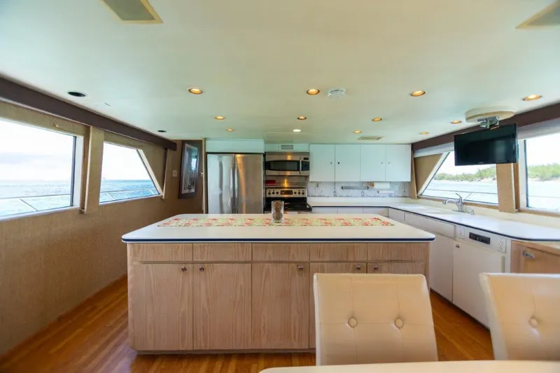 Slide: The Image of Spacious kitchen on a 1991 Broward Motor Yacht with modern appliances and large windows. - 34