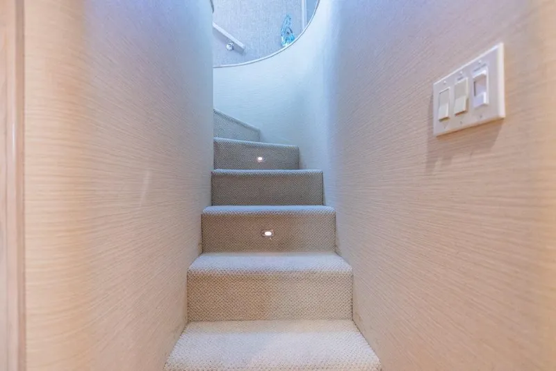 Slide: The Image of Carpeted stairs with LED lights on a 1991 Broward Motor Yacht. - 40