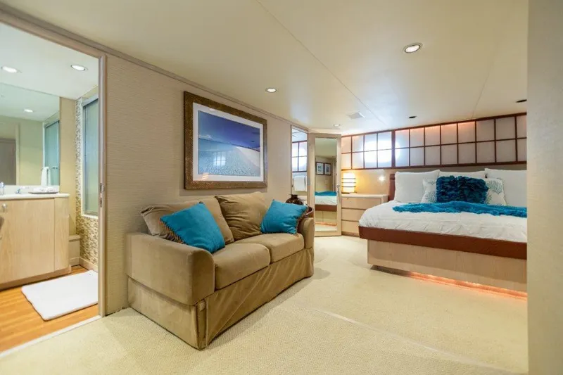 Slide: The Image of Luxurious bedroom in a 1991 Broward Motor Yacht with ensuite bathroom and cozy seating area. - 46