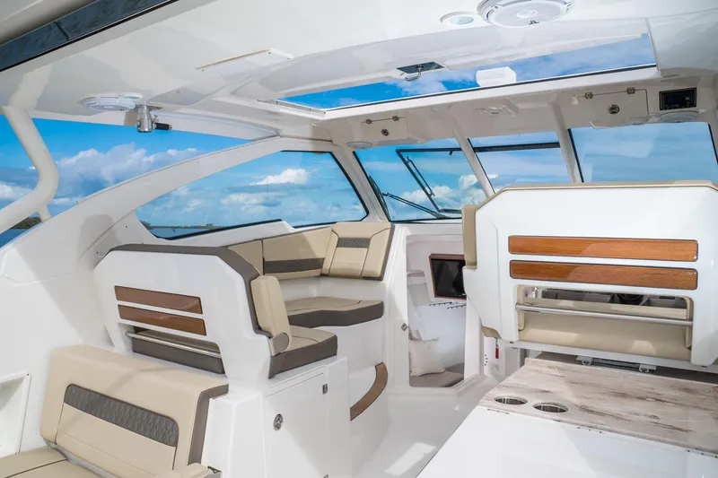 Slide: The Image of Interior of 2025 Pursuit DC 365 Dual Console boat with luxurious seating and panoramic windows. - 13