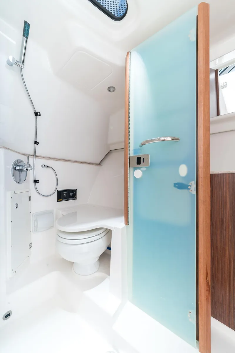 Slide: The Image of 2025 Pursuit DC 365 Dual Console boat bathroom with modern fixtures and frosted glass door. - 17