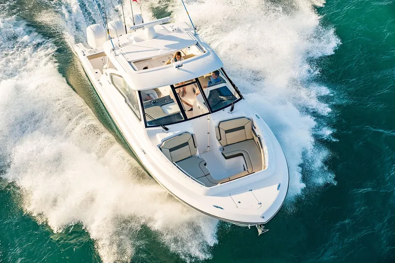 Slide: The Image of 2025 Pursuit DC 365 Dual Console boat cruising on open water. - 26