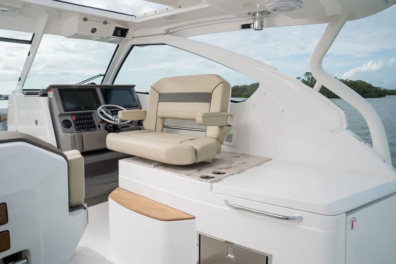 Slide: The Image of 2025 Pursuit DC 365 Dual Console boat interior with captain's chair and control panel. - 6
