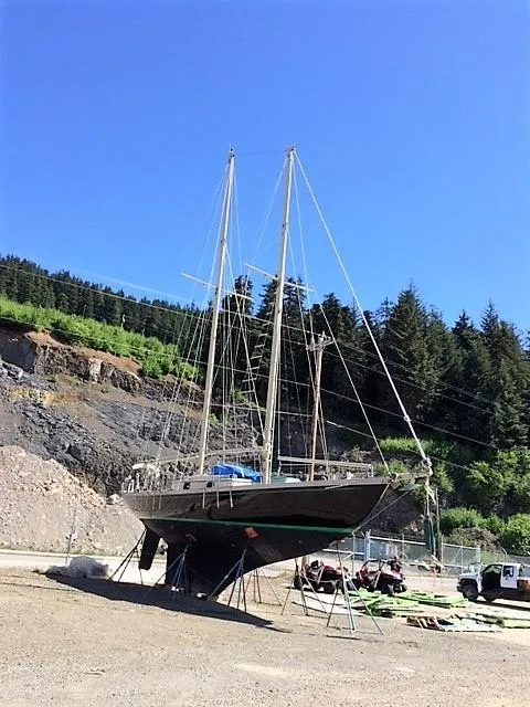 Slide: The Image of 1979 Worldcruiser schooner on land, surrounded by trees and clear blue sky. - 26