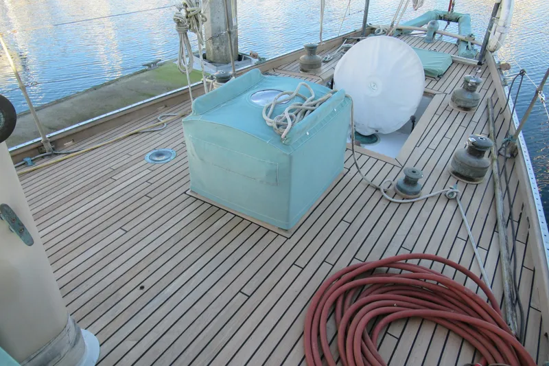 Slide: The Image of 1979 Worldcruiser schooner deck with ropes and equipment, docked by the water. - 28