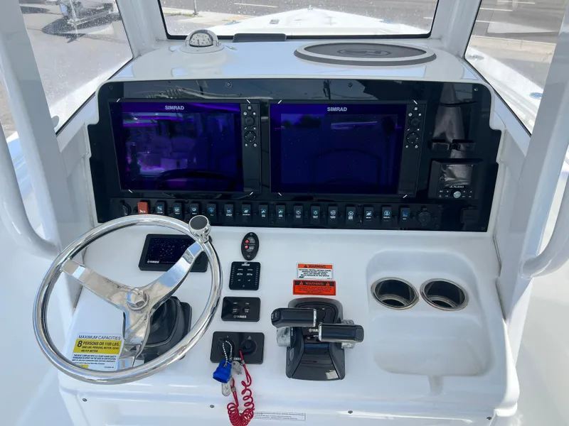 Slide: The Image of 2018 Sea Hunt Gamefish 25 dashboard with dual Simrad displays and steering wheel. - 10