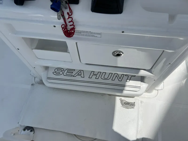 Slide: The Image of 2018 Sea Hunt Gamefish 25 boat interior with storage compartments and Sea Hunt branding. - 11