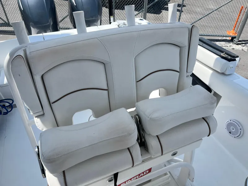 Slide: The Image of 2018 Sea Hunt Gamefish 25 boat seats with cushioned armrests and rod holders. - 12