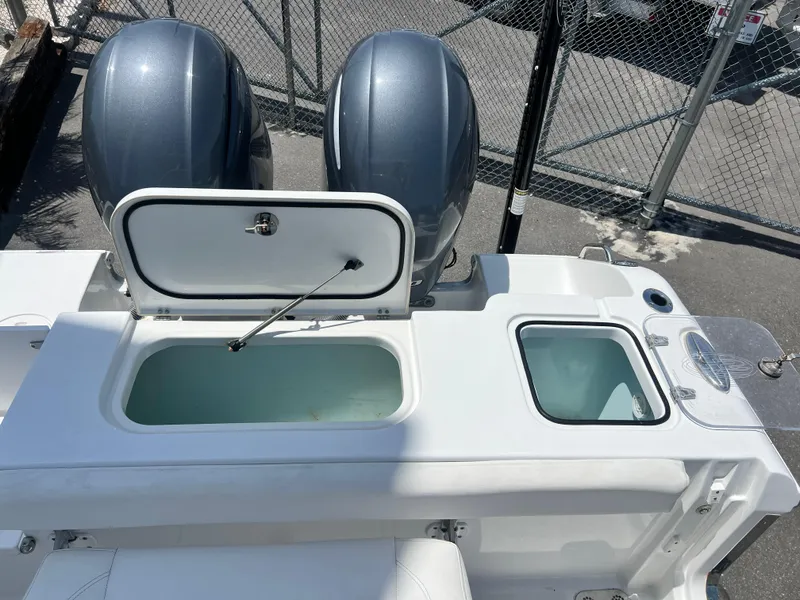 Slide: The Image of 2018 Sea Hunt Gamefish 25 boat with dual engines and open storage compartments. - 16