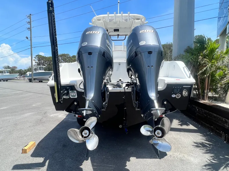Slide: The Image of 2018 Sea Hunt Gamefish 25 with dual outboard engines, parked outdoors. - 4