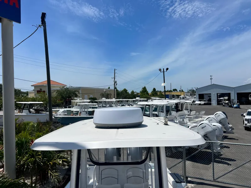Slide: The Image of 2018 Sea Hunt Gamefish 25 boats displayed in a dealership lot under a clear blue sky. - 9