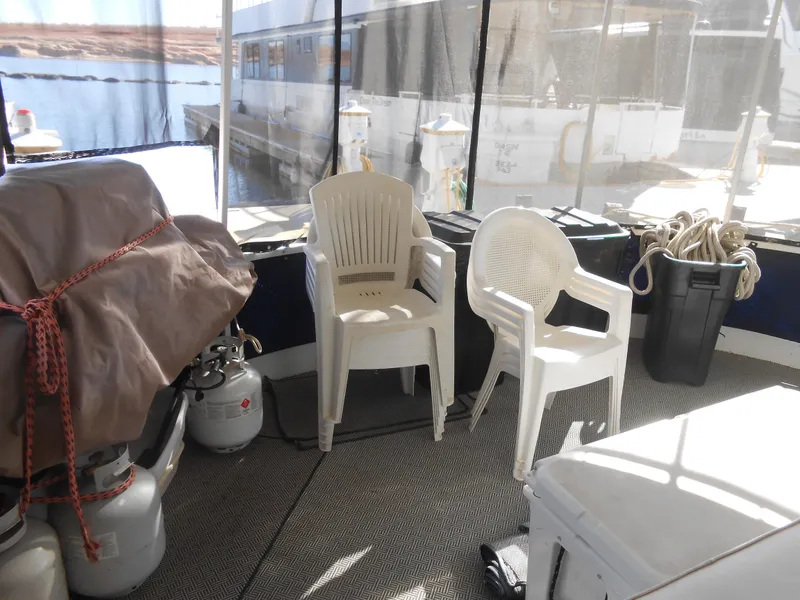 Slide: The Image of 1990 Skipperliner Custom Houseboat interior with chairs, propane tanks, and storage bins. - 10