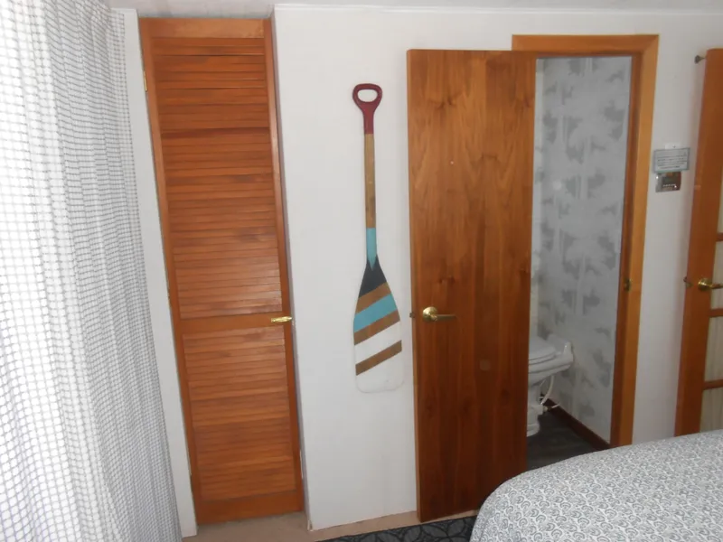 Slide: The Image of Interior of 1990 Skipperliner Custom Houseboat with wooden doors and decorative paddle. - 11