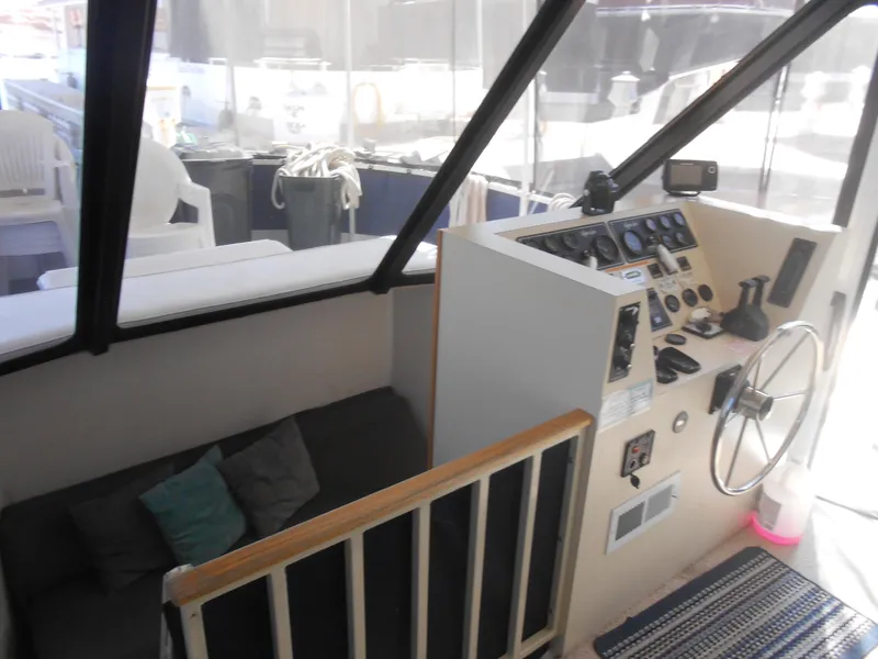 Slide: The Image of 1990 Skipperliner Custom Houseboat interior with steering wheel and seating area. - 13
