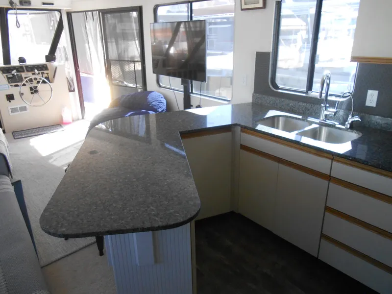 Slide: The Image of Interior of a 1990 Skipperliner Custom Houseboat with modern kitchen and granite countertops. - 18