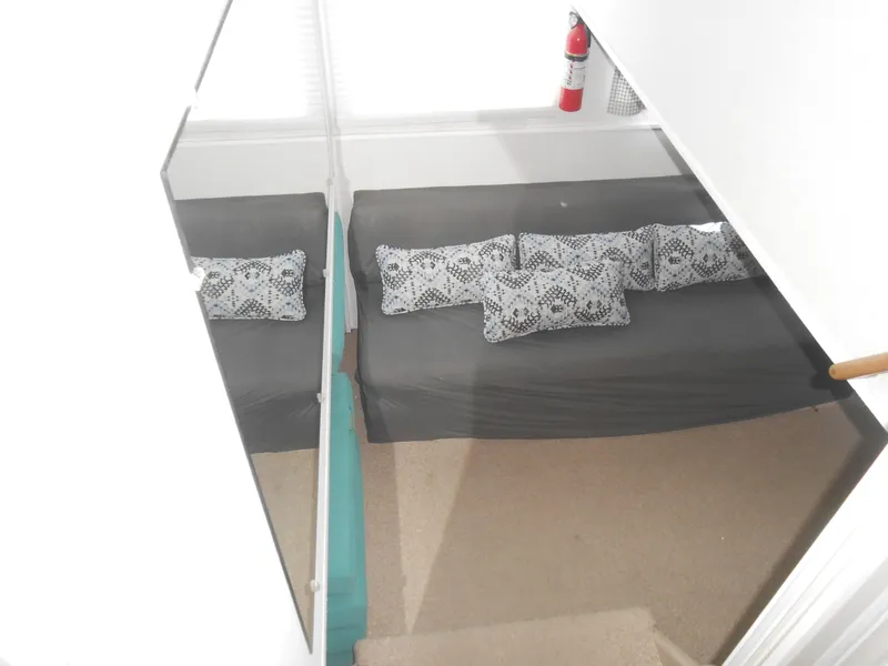 Slide: The Image of Interior of 1990 Skipperliner Custom Houseboat with sofa, patterned cushions, and fire extinguisher. - 21